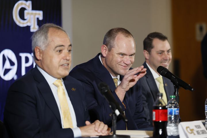 Georgia Tech's new head football coach, Brent Key, waves to his family during his introductory news conference as Tech President Angel Cabrera (left) and athletic director J Batt look on Monday, Dec. 5, 2022.
 Miguel Martinez / miguel.martinezjimenez@ajc.com