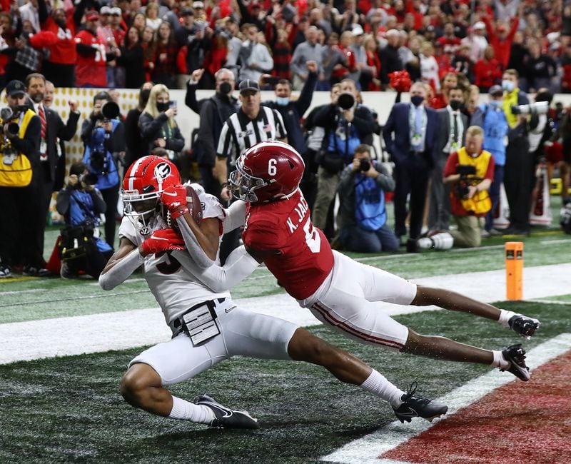 Georgia wide receiver Adonai Mitchell catches the go-ahead touchdown against Alabama defensive back Khyree Jackson to take a 19-18 lead during the 4th quarter in the College Football Playoff Championship game on Monday, Jan. 10, 2022, in Indianapolis.  “Curtis Compton / Curtis.Compton@ajc.com”`