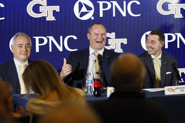 Georgia Tech's new head football coach Brent Key (center) reacts as he answers questions from the media during his introductory news conference as Tech President Angel Cabrera (left) and atheltic director J Batt (right) look on Monday, Dec. 5, 2022.
 Miguel Martinez / miguel.martinezjimenez@ajc.com