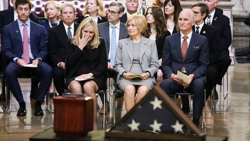 Jean Puckett, seated in foreground center, the wife of retired Army Col. Ralph Puckett Jr., sits with her children, Martha Puckett and Thomas Puckett, during a ceremony at the U.S. Capitol. The remains of Col. Puckett, the last surviving Medal of Honor recipient for acts performed during the Korean War, lie in honor in the Capitol rotunda. Puckett died April 8 at his home in Columbus, Ga., at the age of 97. (Shawn Thew, Pool Photo via AP)