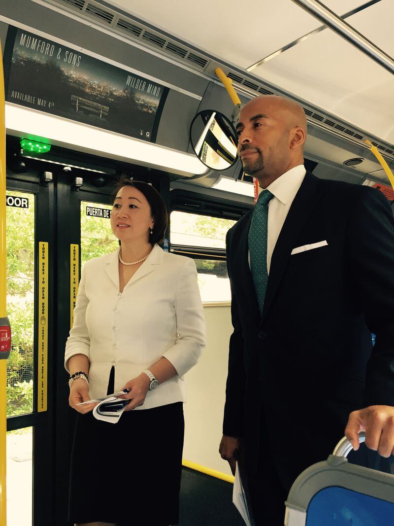 MARTA Chief Information Officer Ming Hsi stands beside CEO Keith Parker on a new transit bus to announce a pilot program that will allow riders to use free wireless internet.