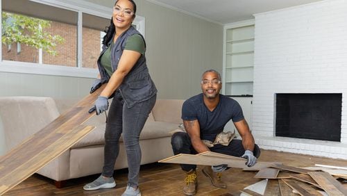 As seen on HGTV's Married to Real Estate, hosts Mike Jackson and Egypt Sherrod (L) remove the old flooring during demo in the Cole's living room. (Working)