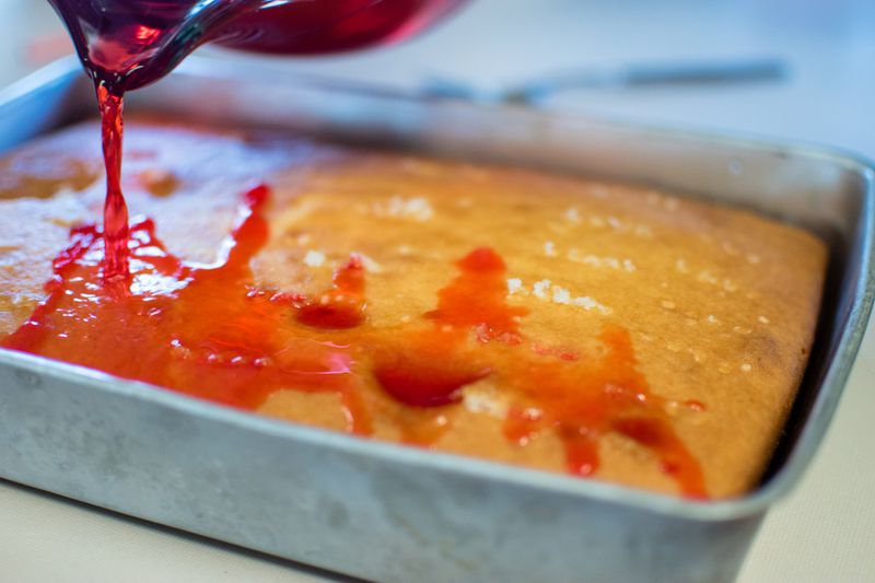Jello is poured over a poke cake filled holes poked with a fork. CONTRIBUTED BY HENRI HOLLIS