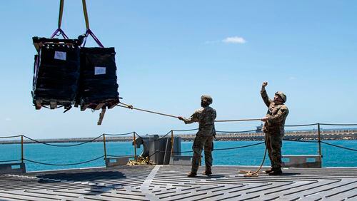 U.S. Army soldiers assigned to the 7th Transportation Brigade (Expeditionary) use a rope to stabilize humanitarian aid while it is lifted by a crane aboard the MV Roy P. Benavidez to support the Joint Logistics Over-the-shore (JLOTS) operation, in the Port of Ashdod, Israel, May 13, 2024. (Staff Sgt. Malcolm Cohens-Ashley/U.S. Army via AP)