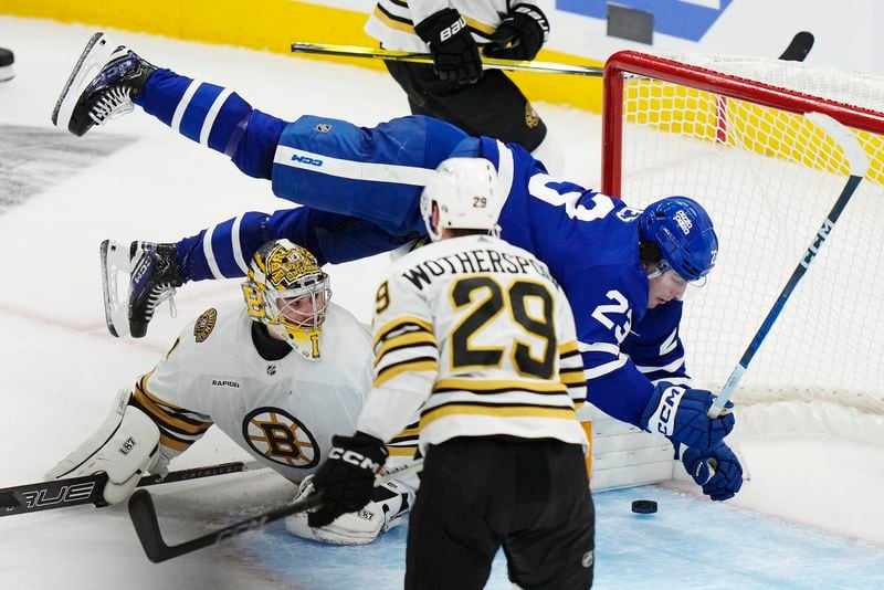 Toronto Maple Leafs' Matthew Knies falls as he scores on Boston Bruins goaltender Jeremy Swayman during the second period of action in Game 3 of an NHL hockey Stanley Cup first-round playoff series in Toronto on Wednesday, April 24, 2024. (Frank Gunn/The Canadian Press via AP)