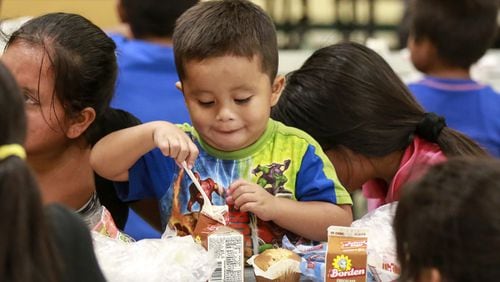 Three-year-old Jesus Miguel Francisco enjoys a free lunch with family members at Highland Elementary in Lake Worth Friday (Bruce R. Bennett / The Palm Beach Post)
