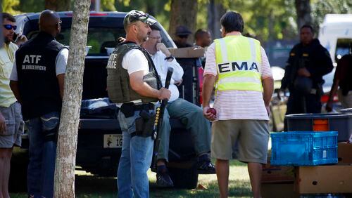 Law enforcement officers gather on the Delta State University campus to search for an active shooter in connection with a the shooting of history professor Ethan Schmidt in his office in Cleveland, Miss., Monday, Sept. 14, 2015. The suspect in the shooting has not yet been identified and remains at large. (AP Photo/Rogelio V. Solis)