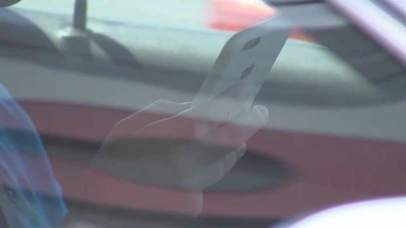 Georgia's distracted driving law requires drivers to use hands-free technology when using cell phones and other electronic devices while driving. But Senate Bill 356 would allow drivers to hold their phones at stoplights and stop signs. (AJC file photo)