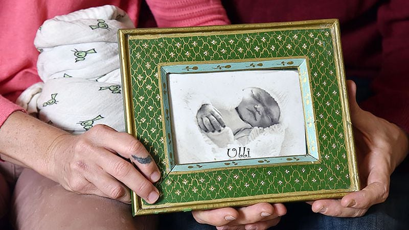 Dara and Mark Ashworth hold a photograph of their stillborn baby Ulli at their home on Tuesday, October 20, 2018. Dara and Mark Ashworth lost their first baby, Ulli, in a stillbirth in 2011. One day she had a heartbeat, the next day she didn't. They say Dr. Brad Bootstaylor showed them test results indicating there might be a problem, but sent them home anyway to await natural birth. They are haunted by whether they could have pushed the doctor to change his mind.