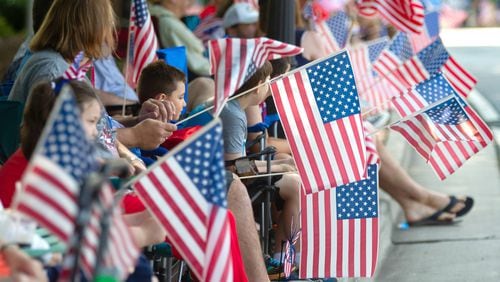 People line Roswell Street with their American flags during the Let Freedom Ring Parade in Marietta on Saturday, July 3, 2021. (Photo: Steve Schaefer for The Atlanta Journal-Constitution)