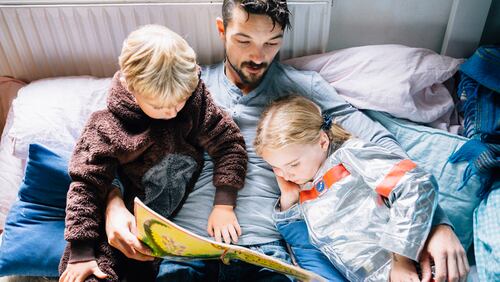 A father reads a book to his children