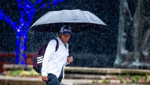 Braving a heavy downpour, this pedestrian, who declined to be identified, crossed Peachtree Street at 15th Street in Midtown Atlanta on Thursday.