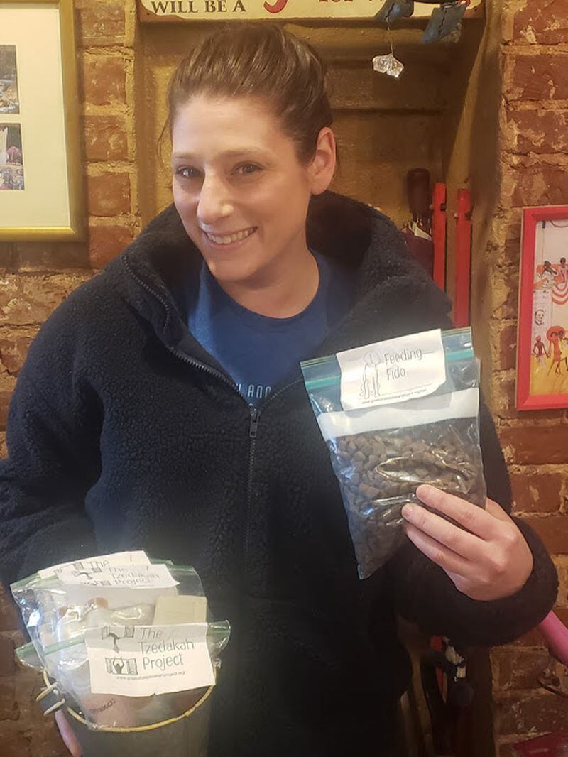 Executive Director Katie Lewis displays complimentary bags of dog food for participants to distribute to those in need and share the message of tzedakah. Courtesy of The Tzedakah Project