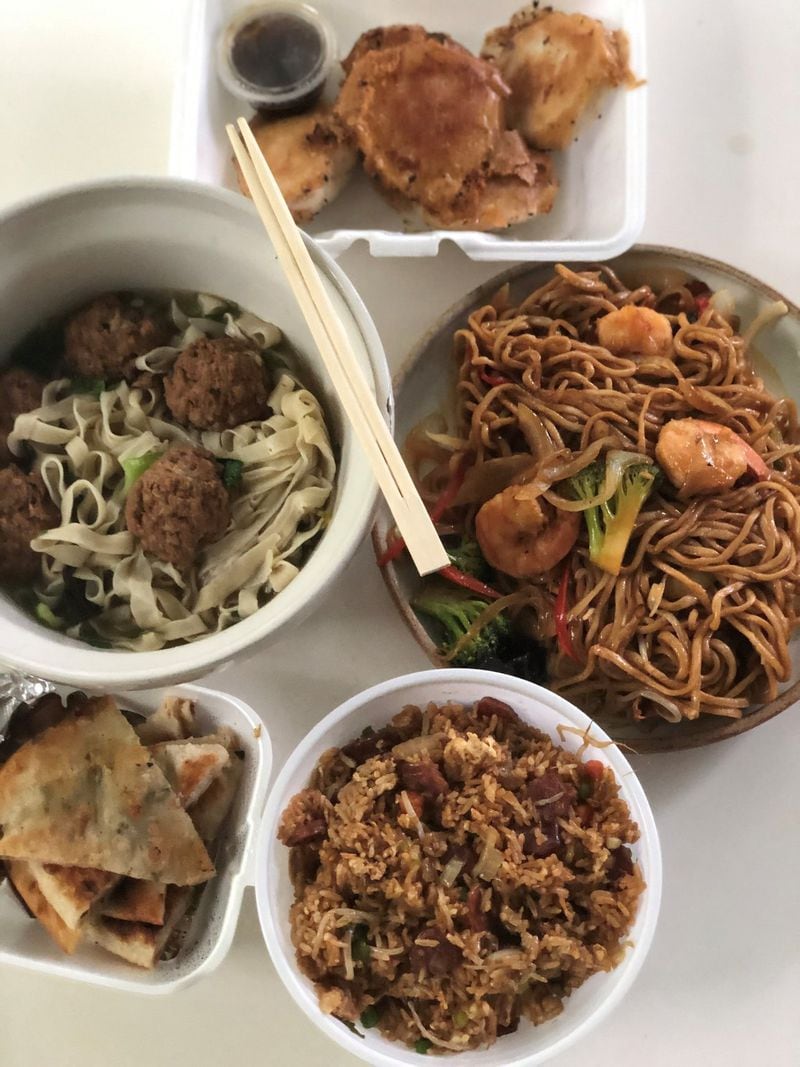 This takeout order from Lan Zhou Ramen on Buford Highway includes (clockwise from top) Shanghai-style pork buns; hand-pulled noodles with shrimp; sausage fried rice, chive pancakes and stewed meatball hand-pulled noodle soup. CONTRIBUTED BY WENDELL BROCK