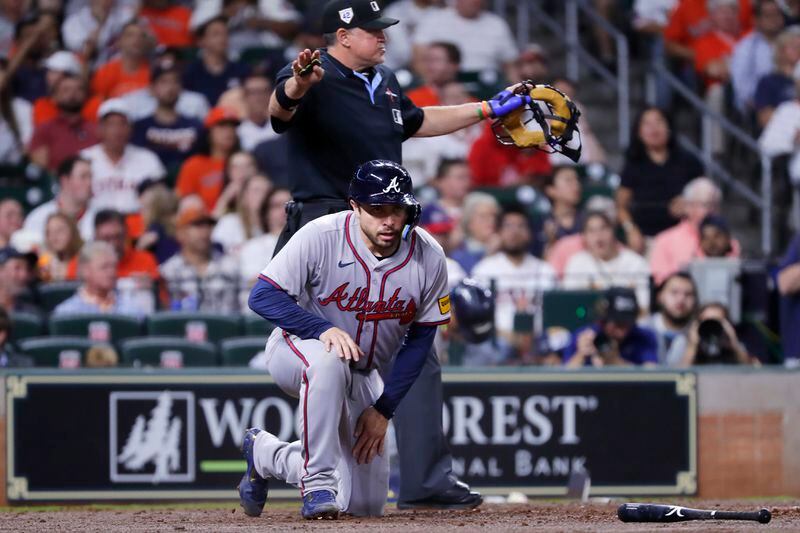 Atlanta Braves' Travis d'Arnaud, bottom, gets up after scoring in front of home plate umpire Tony Randazzo, top, on an RBI single by Braves' Luis Guillorme during the second inning of a baseball game against the Houston Astros, Monday, April 15, 2024, in Houston. (AP Photo/Michael Wyke)