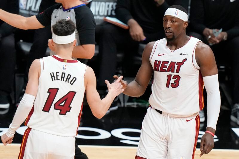 Miami Heat guard Tyler Herro (14) congratulates center Bam Adebayo (13) after a play during the first half of Game 3 of an NBA basketball first-round playoff series against the Boston Celtics, Saturday, April 27, 2024, in Miami. (AP Photo/Wilfredo Lee)
