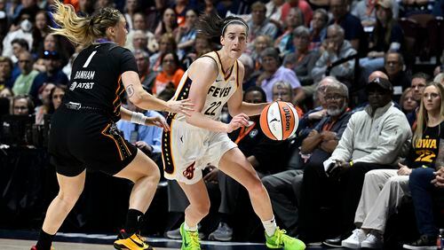 Indiana Fever guard Caitlin Clark (22) drives against Connecticut Sun guard Rachel Banham (1) during the fourth quarter of a WNBA basketball game, Tuesday, May 14, 2024, in Uncasville, Conn. (AP Photo/Jessica Hill)