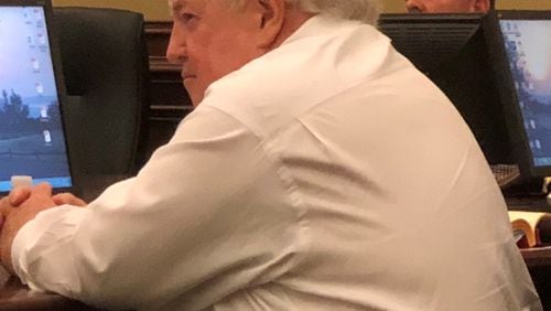Buford City Schools Board of Education Chairman Phillip Beard listens as residents address the board. Some in the audience asked that he step down as chairman, a position he’s held for 44 years. ARLINDA SMITH BROADY/AJC