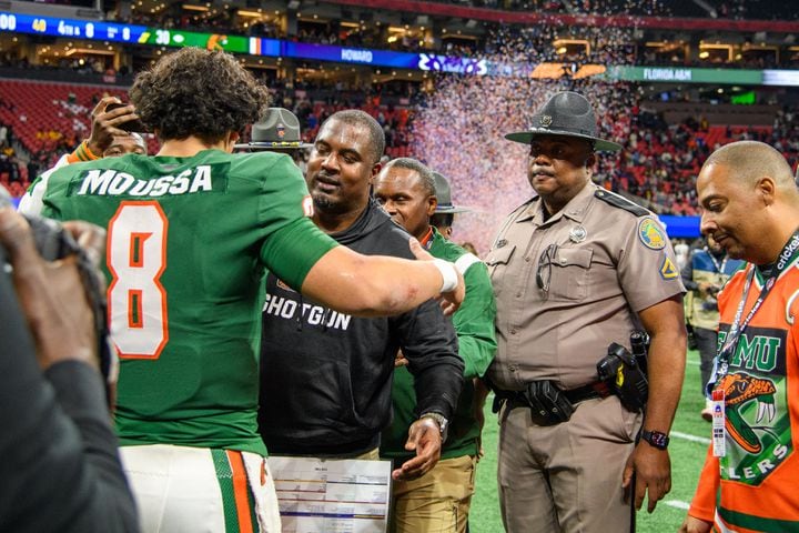 Florida A&M head coach Willie Simmons embraces quarterback Jeremy Moussa after the Celebration Bowl against Howard at Mercedes Benz Stadium in Atlanta, Georgia on Dec. 16, 2023. (Jamie Spaar for the Atlanta Journal Constitution)