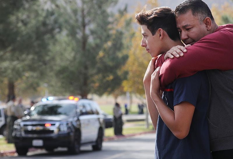Marco Reynoso hugs his son, 11thgrader Dylan Reynoso, after reuniting after the shooting.