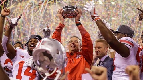 Ohio State coach Urban Meyer holds the trophy after Ohio State defeated Wisconsin 27-21 in the Big Ten championship NCAA college football game, early Sunday, Dec. 3, 2017, in Indianapolis. (AP Photo/Michael Conroy)