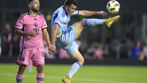 Atlanta United defender Brooks Lennon, right, kicks the ball during the first half of the team's MLS soccer match against Inter Miami on Wednesday, May 29, 2024, in Fort Lauderdale, Fla. At left is Inter Miami defender Jordi Alba (18). (AP Photo/Lynne Sladky)