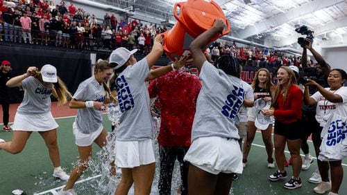 Georgia first-year coach Drake Bernstein (in red) gets a surprise dunking from his players after the Bulldogs won the SEC women's tennis tournament championship inside the Lindsey Hopkins Indoor Tennis Facility with Dan Magill Tennis Complex in Athens, Ga., on Sunday, April 21, 2024. (Conor Dillon/UGA Athletics)