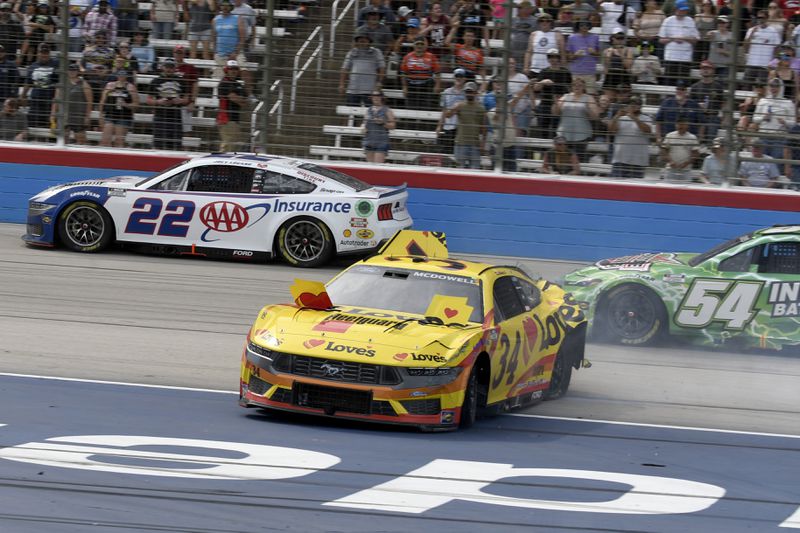 Michael Mcdowell (34) crashes coming out of Turn 4 as Joey Logano (22) and Ty Gibbs (54) race past during a NASCAR Cup Series auto race at Texas Motor Speedway in Fort Worth, Texas, Sunday, April 14, 2024. (AP Photo/Randy Holt)