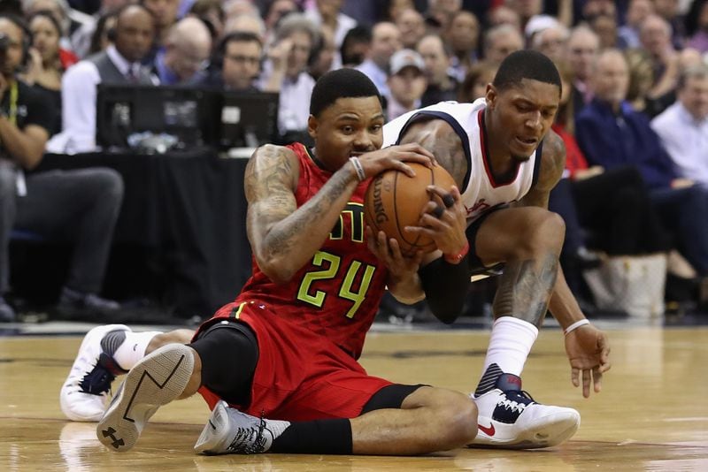 Kent Bazemore #24 of the Atlanta Hawks and Bradley Beal #3 of the Washington Wizards go after a loose ball in the first half in Game Five of the Eastern Conference Quarterfinals during the 2017 NBA Playoffs at at Verizon Center on April 26, 2017 in Washington, DC. Photo by Rob Carr/Getty Images