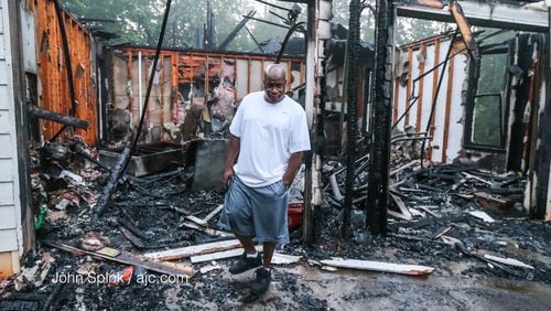 Bill Thomas walked through his mother’s burned home after a fire in DeKalb County. JOHN SPINK / JSPINK@AJC.COM