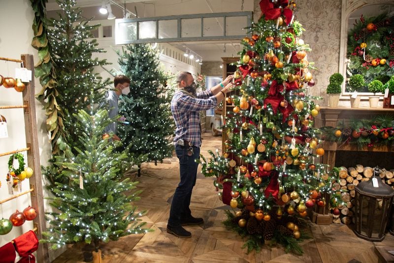 Park Hill Collection employee Miguel Garcia tends to a Christmas tree in their AmericasMart showroom in Atlanta, August 14, 2020.  STEVE SCHAEFER FOR THE ATLANTA JOURNAL-CONSTITUTION