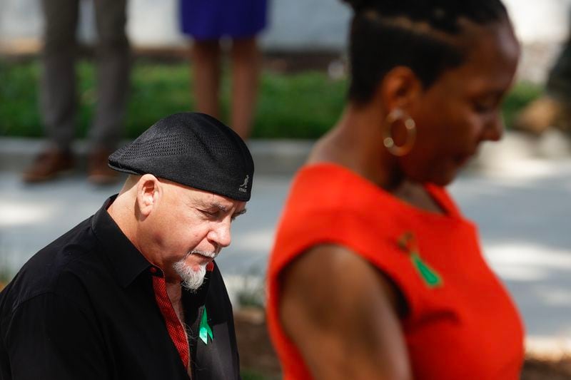 (Left to right) Gordon Huether, the artist commissioned to create the Atlanta Children’s Eternal Flame Memorial and Former Mayor Keisha Lance Bottoms bow their heads for a moment of silence for the victims during the unveiling ceremony on Tuesday, June 27, 2023. The memorial was created to honor the lives of children killed during the Atlanta Child Murders. (Natrice Miller/ Natrice.miller@ajc.com)