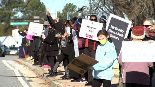 Some DeKalb residents, including those pictured at this protest in December, may be relieved to know that the school reopening will be delayed.