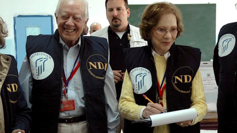 In this image released by the Carter Center, former U.S. President Jimmy Carter, left, and his wife Rosalyn smile as they visit a polling station during the Palestinian parliamentary elections in Arab east Jerusalem Wednesday Jan. 25, 2006. Nearly 20,000 local observers and 950 international monitors, led by Carter, watched the vote. (AP Photo/Deborah Hakes, The Carter Center)