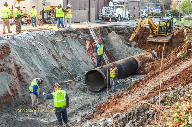 Crews are still in the process of installing a new water main in DeKalb County following a massive break. JOHN SPINK / JSPINK@AJC.COM