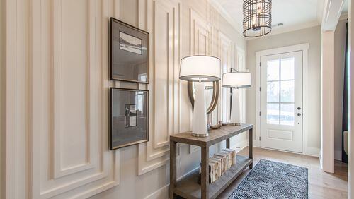 Edward Andrews Homes uses picture framing wainscoting in a home in Alpharetta’s Larkspur community as a focal point in the foyer. Layers of trim painted the same color as the wall brings depth to the foyer. CONTRIBUTED BY: Edward Andrews Homes