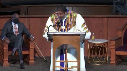The Rev. William J. Barber II speaks at the Sunday service, March 21, 2021, at Ebenezer Baptist Church as senior pastor Raphael Warnock looks on. (Photo via Ebenezer livestream)
