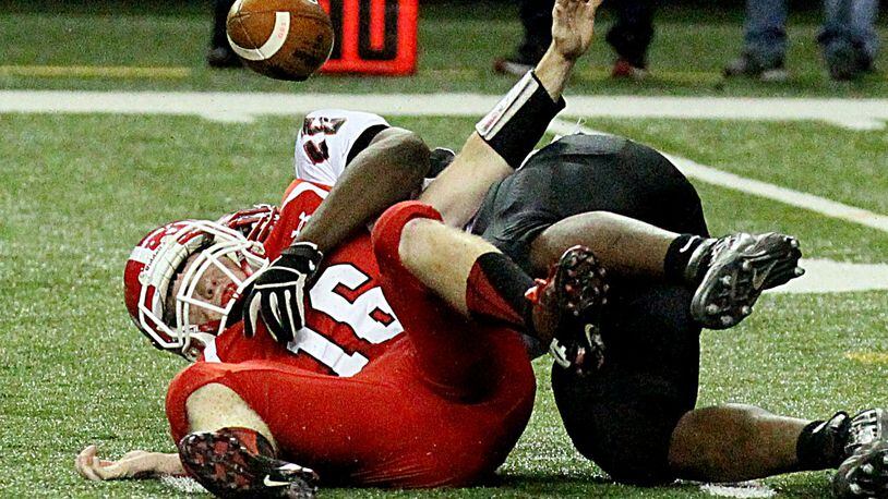 Marion County's (Buena Vista, GA) quarterback #16 Justin Eckert is sacked by Charlton County's (Folkston) #55 Teon Burroughs causing a fumble that Marion County recovered during their GHSA Class A-Public Football Championship game at the Georgia Dome in Atlanta on Saturday, December 14, 2013.