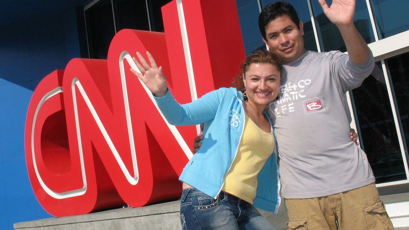 Yady Liliana Rivera-Tovar, left, and A. Quitian right, from Colombia, South America,  pose for a souvenir photo in front of the CNN sign downtown. The news channel is so intimately associated with Atlanta that tourists make a point of posing in front of the sign when they visit.    (Kimberly Smith / AJC staff)