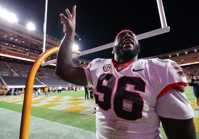 Georgia defensive lineman Zion Logue flashes a victory sign leaving the field with a 38-10 victory over Tennessee in a NCAA college football game on Saturday, Nov. 18, 2023, in Knoxville.  Curtis Compton for the Atlanta Journal Constitution