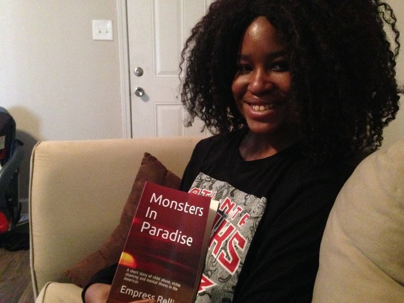 Empress Rellise holds a copy of her book, “Monsters in Paradise: A Short Story of Child Abuse, Victim Shaming and Mental Illness in the Americas.” Writing the book helped her process the sexual abuse she had suffered. GRACIE BONDS STAPLES / GSTAPLES@AJC.COM
