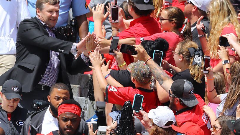 Kirby Smart high-fives some fans while others film his entry into Sanford Stadium Saturday for Georgia's G-Day game.