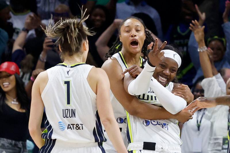 Dallas Wings guard Arike Ogunbowale, right, is mobbed by teammates, Sevgi Uzun (1) and Jaelyn Brown, center, after Ogunbowale made a three point shot that helped them defeat the Indiana Fever during an WNBA basketball game in Arlington, Texas, Friday, May 3, 2024. (AP Photo/Michael Ainsworth)