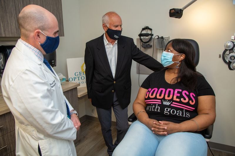 Dr. Scott Moscow (from left) and Dr. Billy Moscow talk with Jenita Holbrook at Roswell Eye Clinic in Roswell. PHIL SKINNER FOR THE ATLANTA JOURNAL-CONSTITUTION.