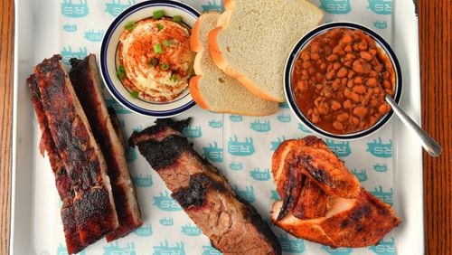 This three-meat plate at Rodney Scott's Whole Hog BBQ in southwest Atlanta has ribs, brisket and bone-in chicken, with potato salad and baked beans. (Chris Hunt for The Atlanta Journal-Constitution)