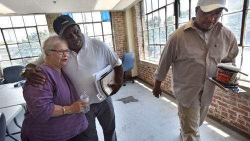 Anita Beaty (left) gets a  hug from Jerome Baker as Urguehart Rudy (right) leaves after a meeting with Transitional Housing Program participants at the Peachtree-Pine  shelter on Thursday, July 13, 2017. HYOSUB SHIN / HSHIN@AJC.COM