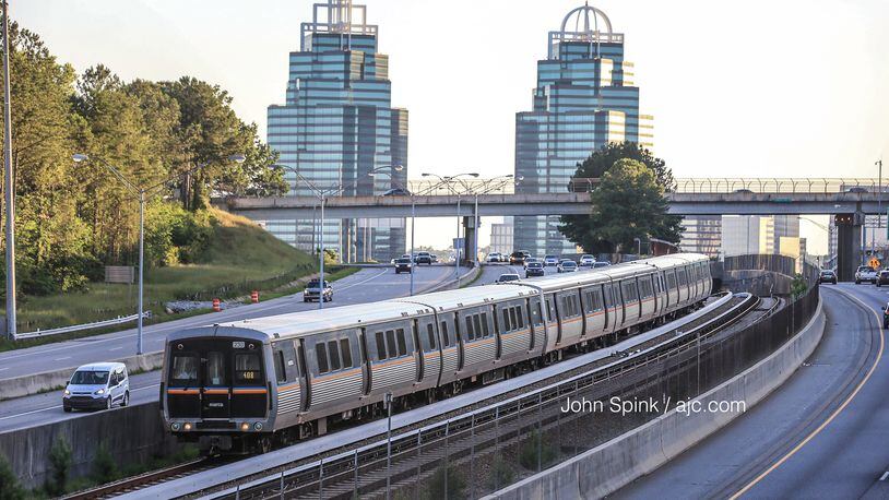 A MARTA train heads southbound from the Medical Center station on the red line Monday morning, hours after a crash involving a train and a contractor shut down the line overnight. JOHN SPINK / JSPINK@AJC.COM