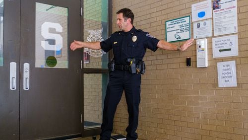 Gwinnett County Public Schools Police Chief Tony Lockard demonstrates the district’s new front entrance security and sign-in system at Collins Hill High School in Suwanee. (Arvin Temkar / arvin.temkar@ajc.com)