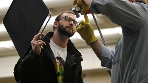 Barton Bond, the director of program curriculum at the Georgia Film Academy, helps student, Justin Nesbit, 26, set up lighting equipment during the on-set film production class at Gwinnett Technical College. The class is part of the Georgia Film Academy Certificate Program that will prepare students for on-set jobs in the film industry. TAYLOR CARPENTER / TAYLOR.CARPENTER@AJC.COM