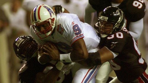 980807 ATLANTA: Oilers' quarterback Steve McNair (9,cq) drags three Falcons along with him as he scrambles upfield for a first down in second quarter action at the Georgia Dome in preseason action 8/7/98. The players holding onto McNair are Cornelius Bennet (L), Chuck Smith (R), and Lester Archambeau (92, all cq). (DAVID TULIS/Staff)